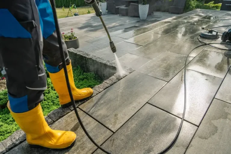 Close up of a pressure washer being used to clean a clients backyard pavement